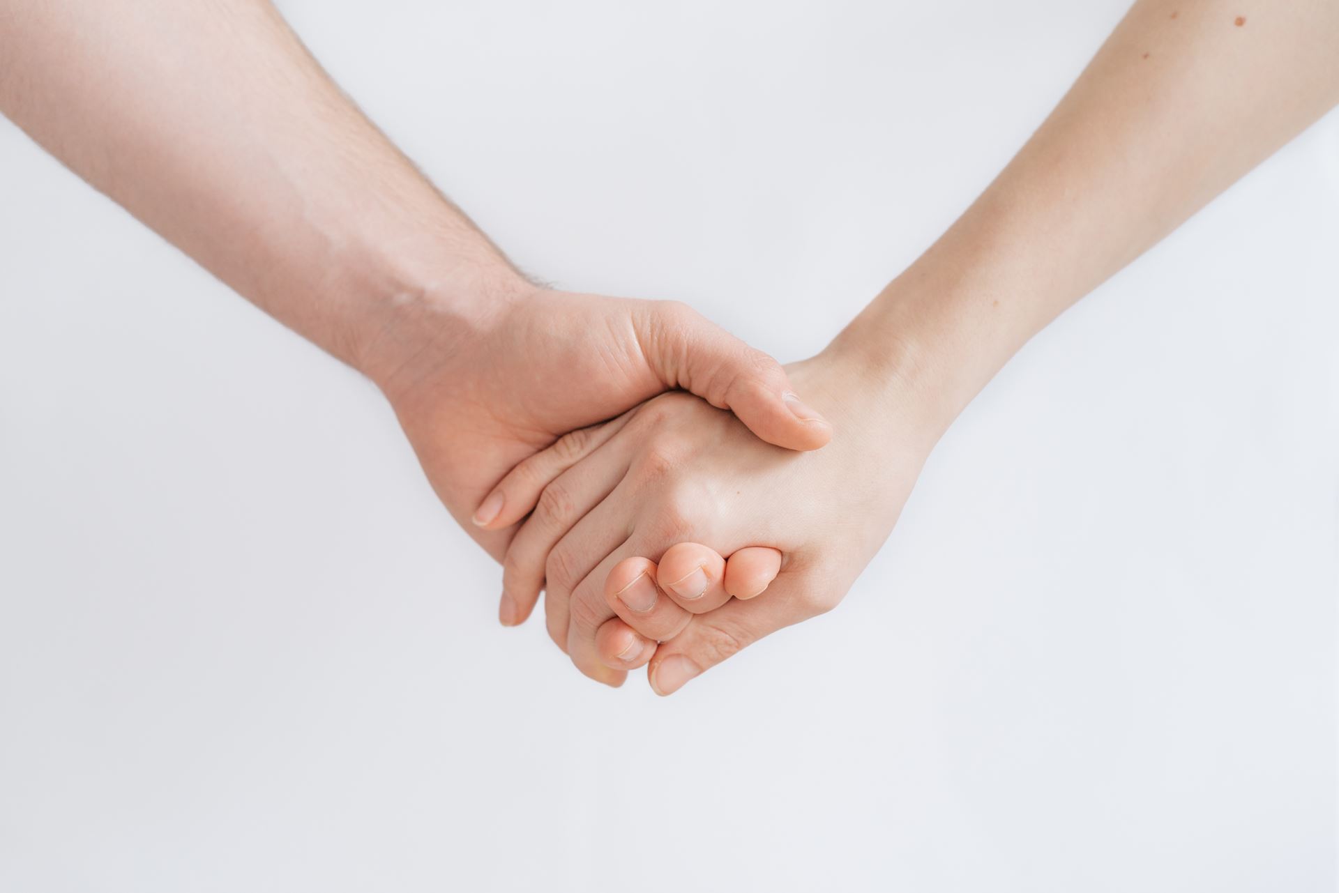 a close up of two people holding hands